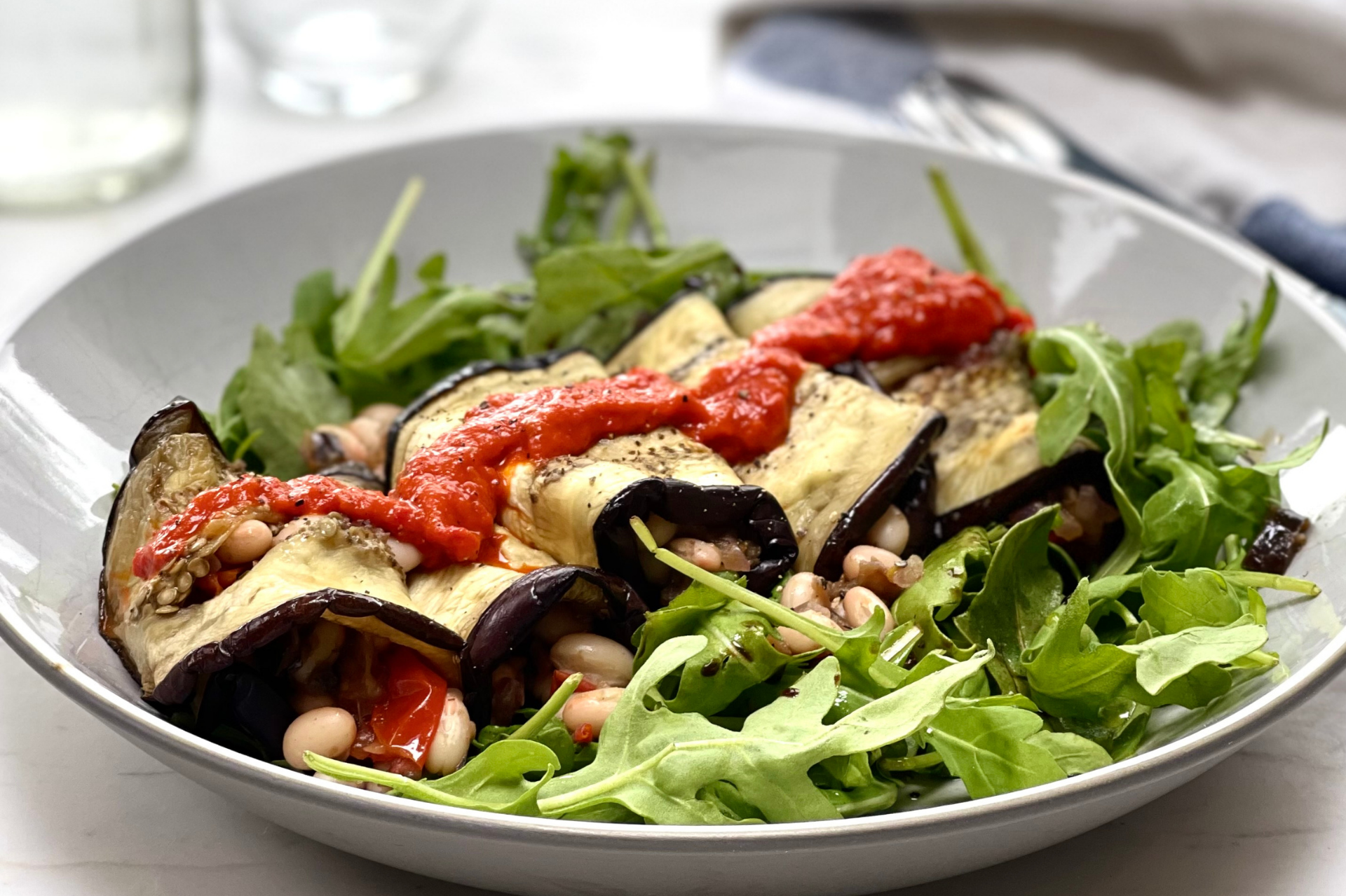 Stuffed aubergine wraps with roasted pepper and basil sauce